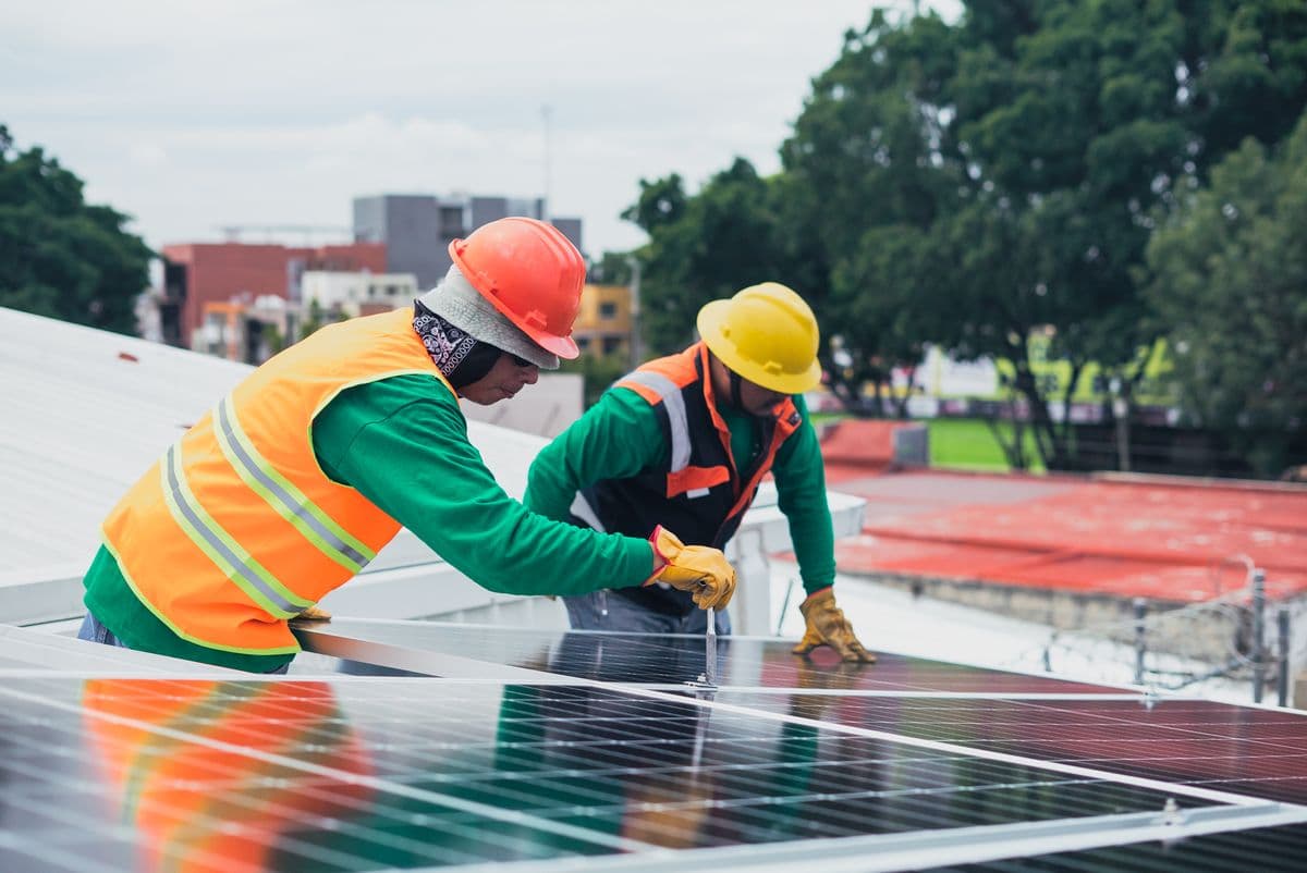 Technicians installing rooftop solar panels
